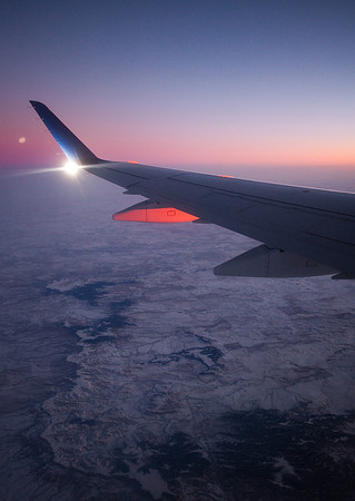 A Delta Airline plane's wing lit up by the sun.  Image taken during sunrise over Montana/Dakotas